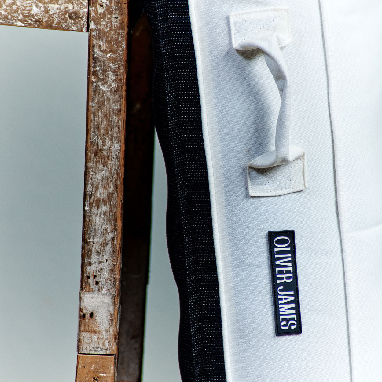 The trims of a white luxury pool float leaning against a stool in a warehouse.