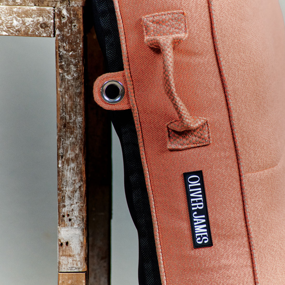 The trims of a orange luxury pool float leaning against a stool in a warehouse.