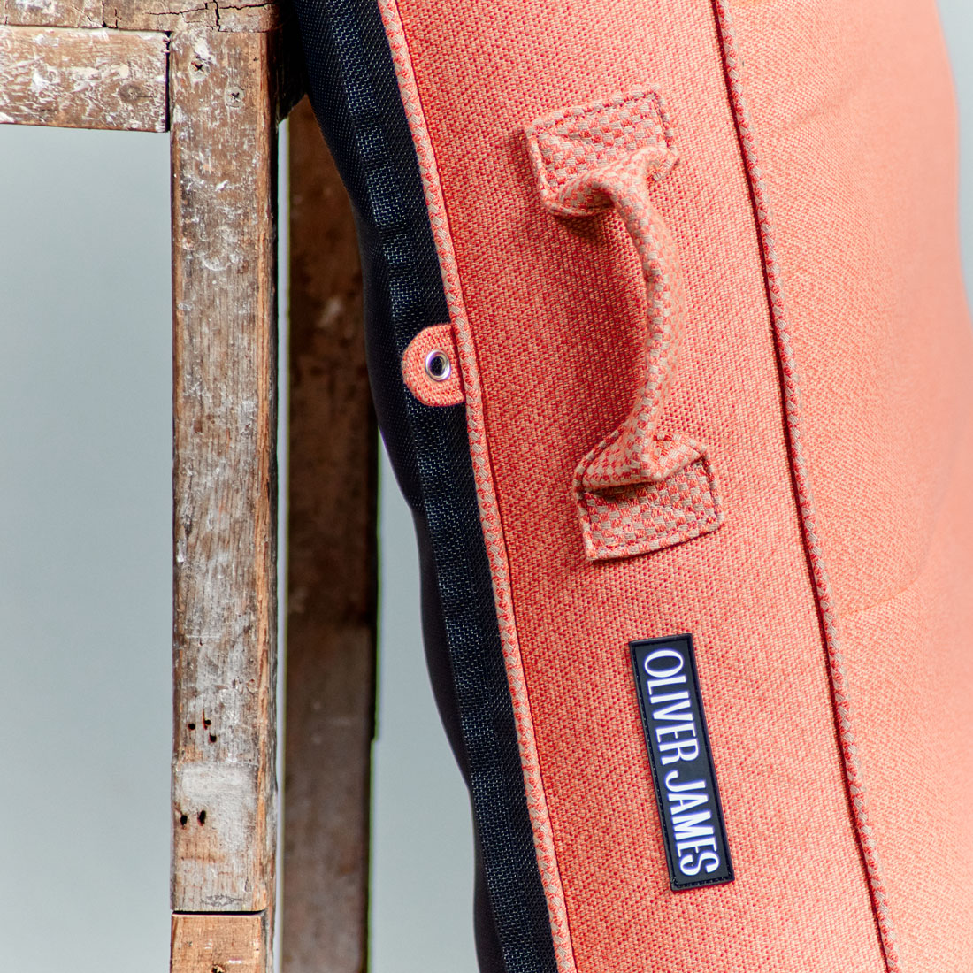 The trims of an orange luxury pool float leaning against a stool in a warehouse.