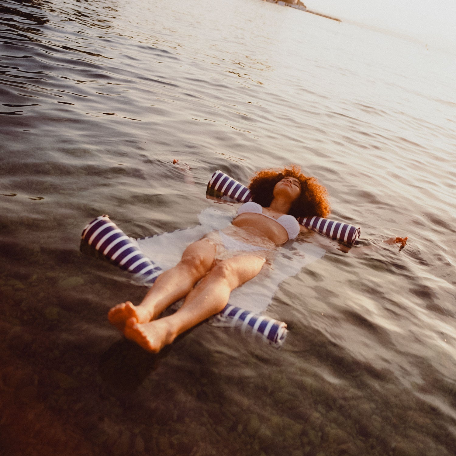 A woman floating in the sea on a beach float for adults.