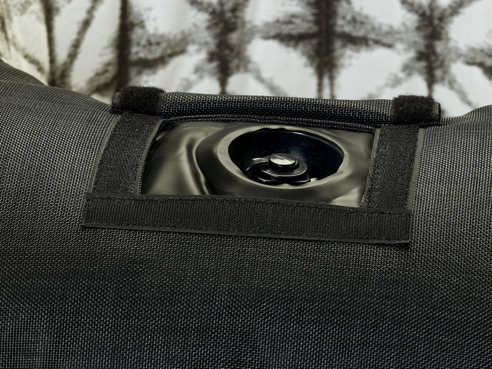 A ring luxury lilo in a grey and white fabric upside down displaying the base and velcro window to access the boston valve.