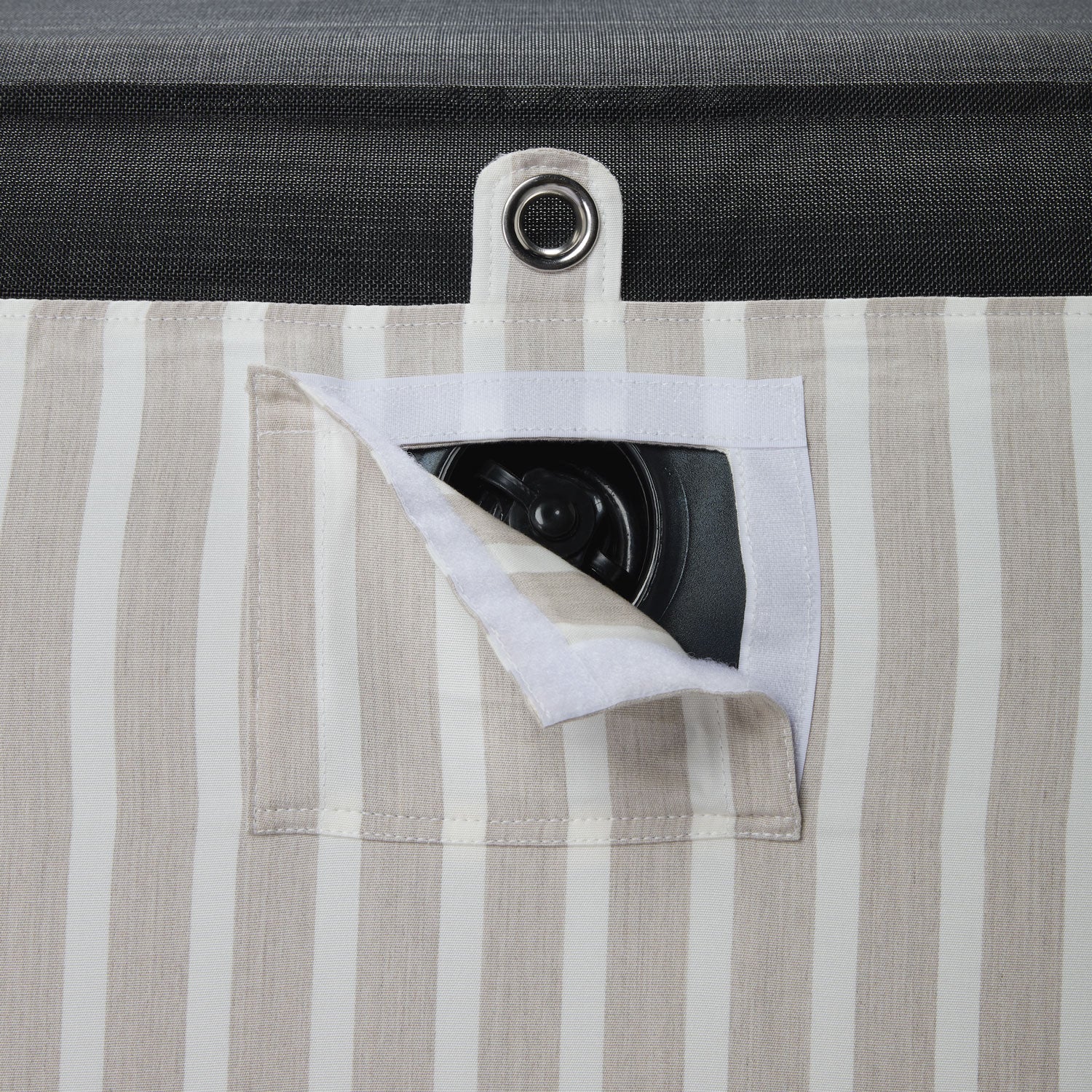 A pool float for an adult in a beige and white stripe fabric upside down with a eyelet and velcro window showing a boston valve.  