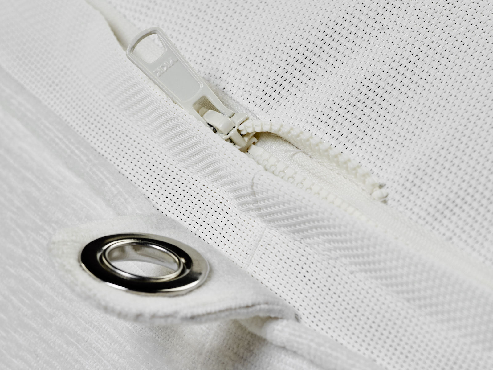 A luxury pool float ring lounger in a white terry towel fabric upside down displaying stainless steel eyelets, a durable base and zippers.