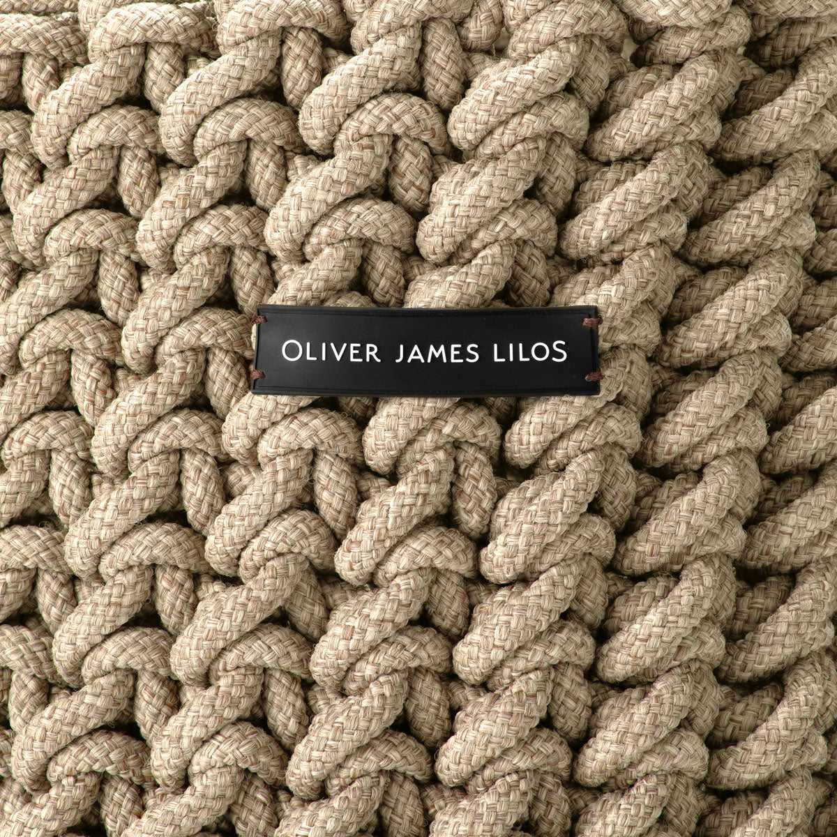 A hand-woven brown rope basket with the logo "Oliver James Lilos".