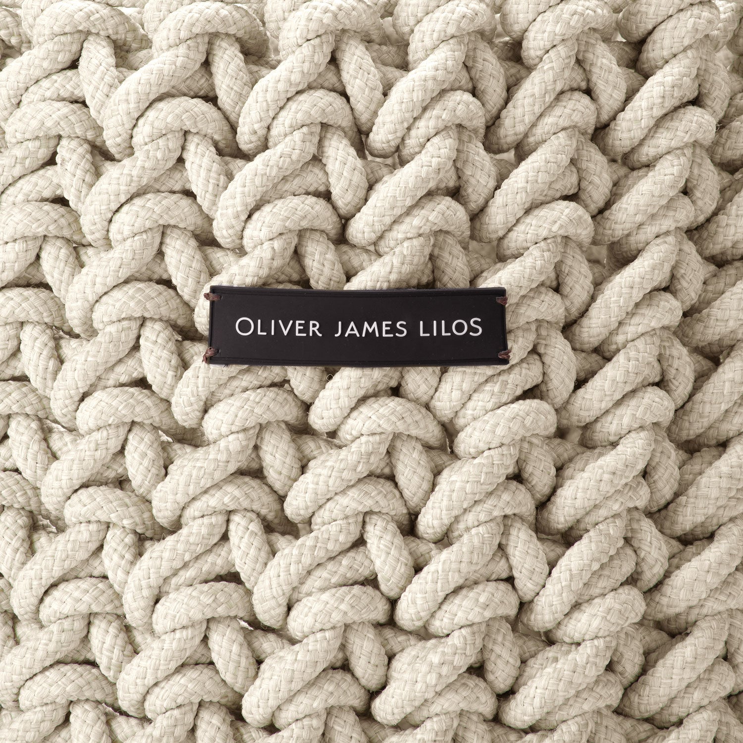 A hand-woven white rope basket with the logo "Oliver James Lilos".