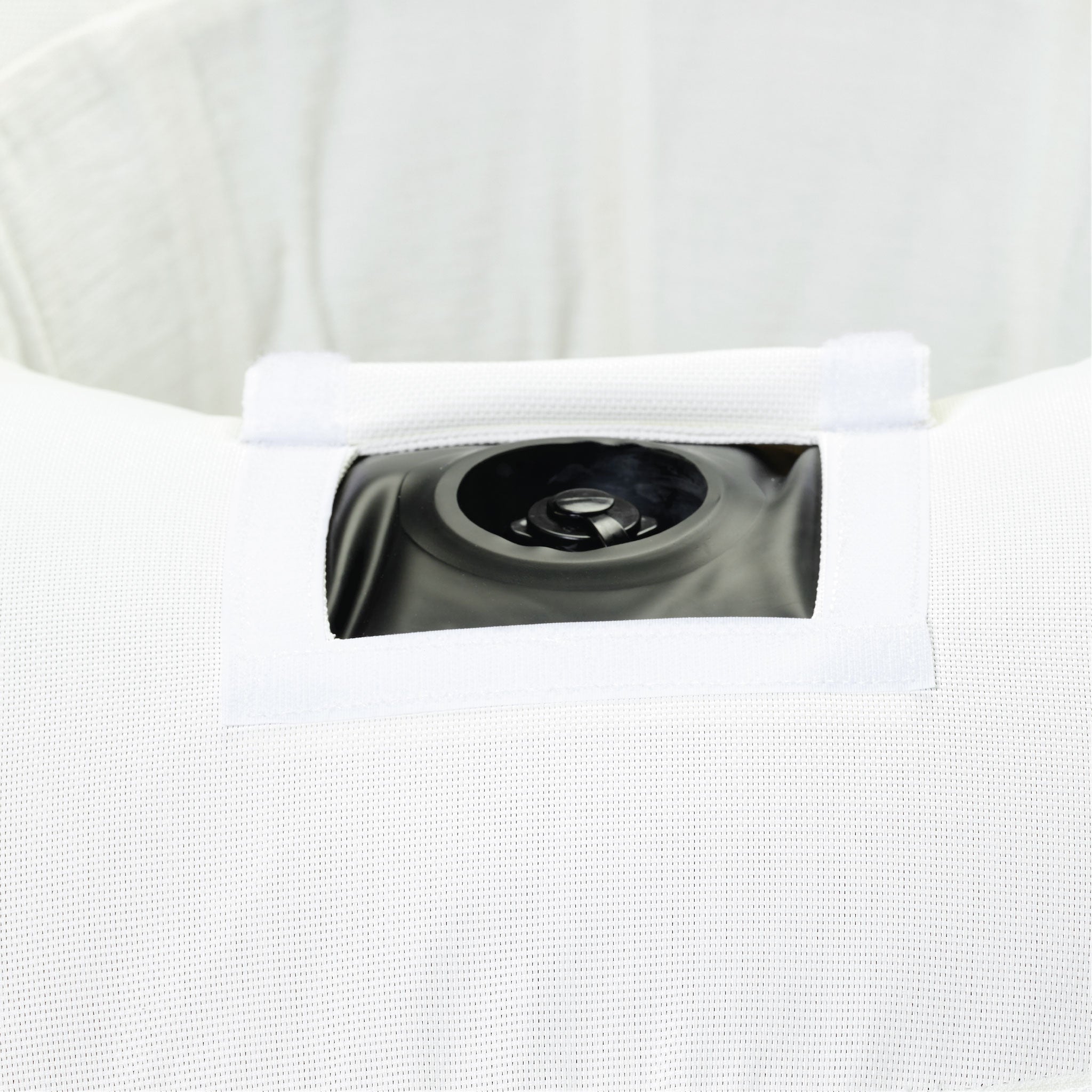 A ring luxury lilo in a white terry toweled fabric upside down displaying the base and velcro window to access the boston valve.