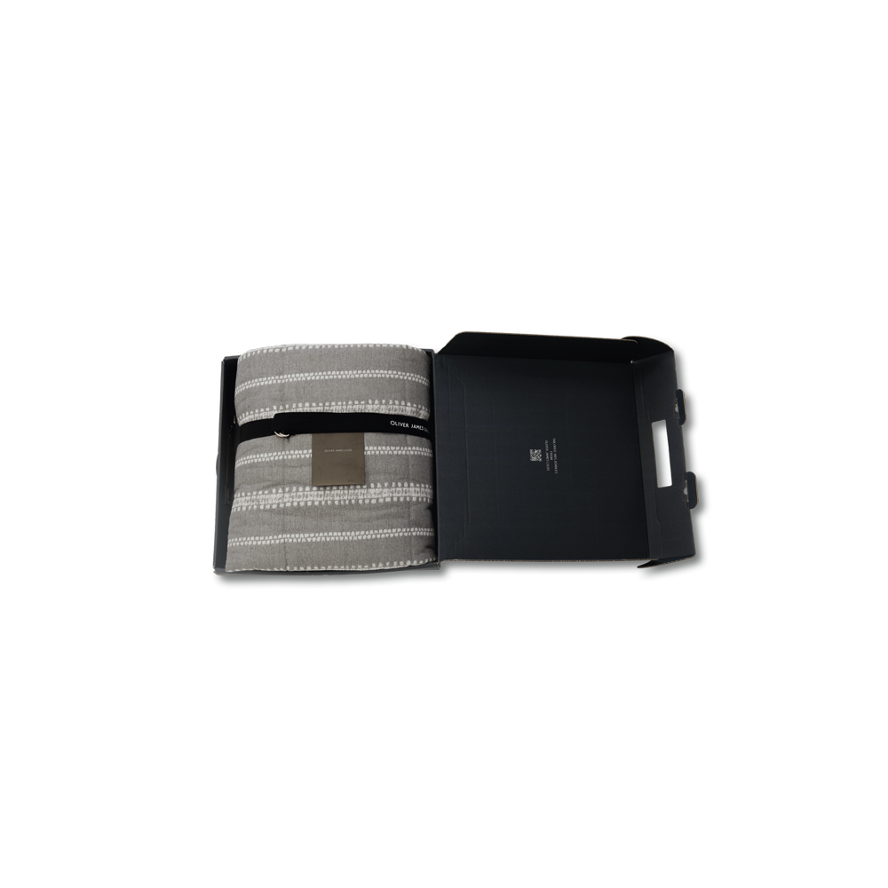 Solitaire housse de flotteur gonflable de luxe pour piscine à rayures grises et blanches, pliée dans une boîte noire avec une ceinture, une carte et une pompe.