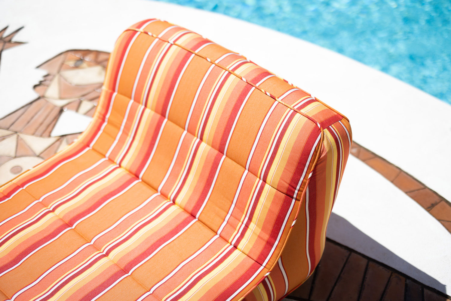 A orange and white luxury pool float sitting on a white Jupiter at Hotel Byblos Saint Tropez