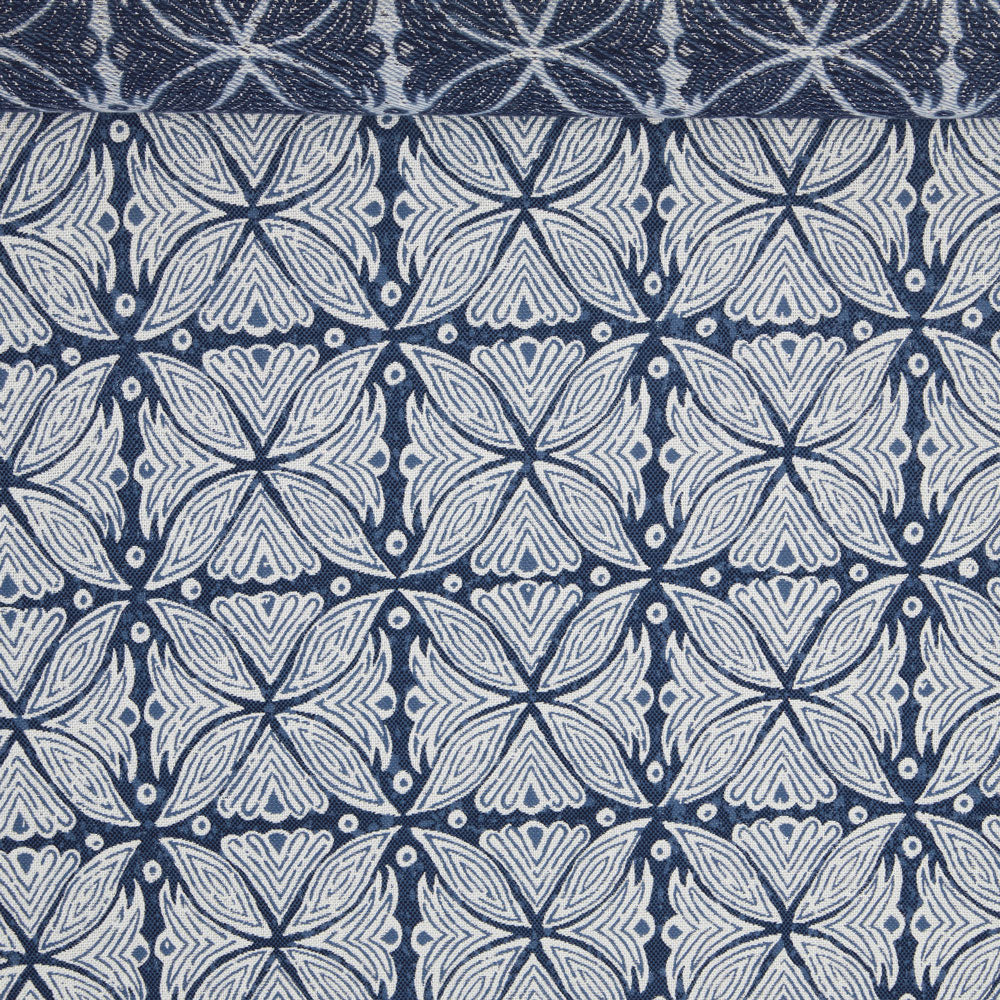 A birds eye view of a jacquard woven blue and white pattern outdoor performance fabric roll. 
