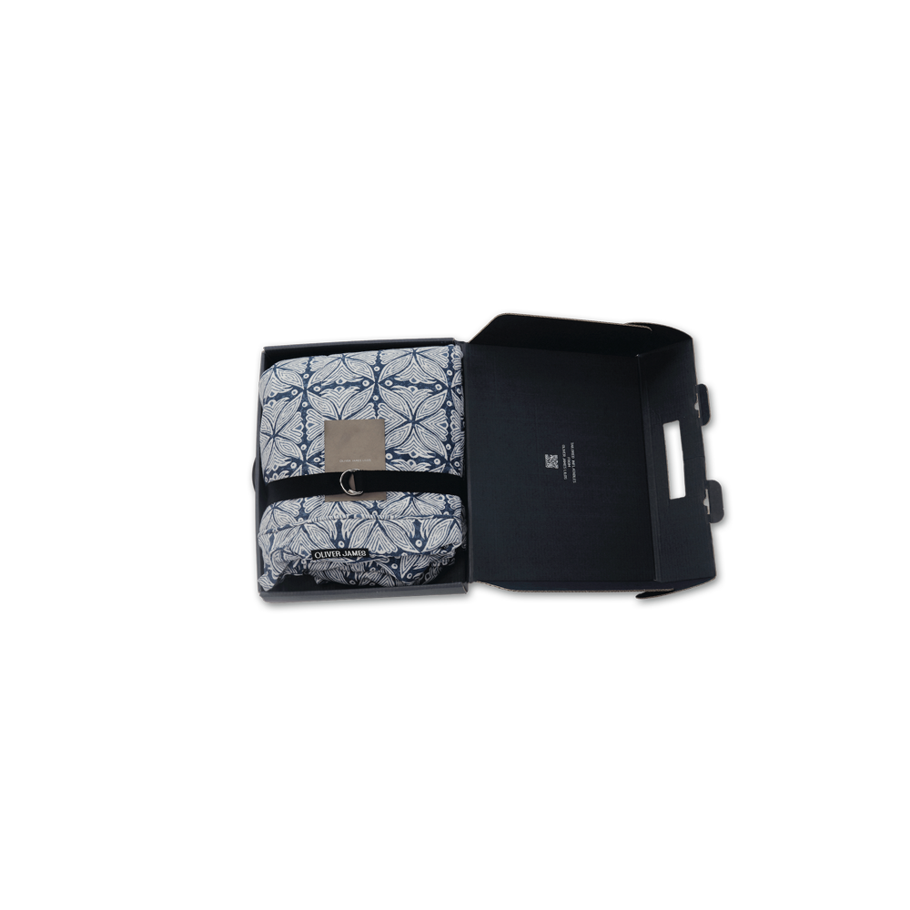 Un Solitaire à motifs bleus et blancs, flotteur gonflable de luxe pour piscine, plié dans une boîte noire avec une ceinture, une carte et une pompe.