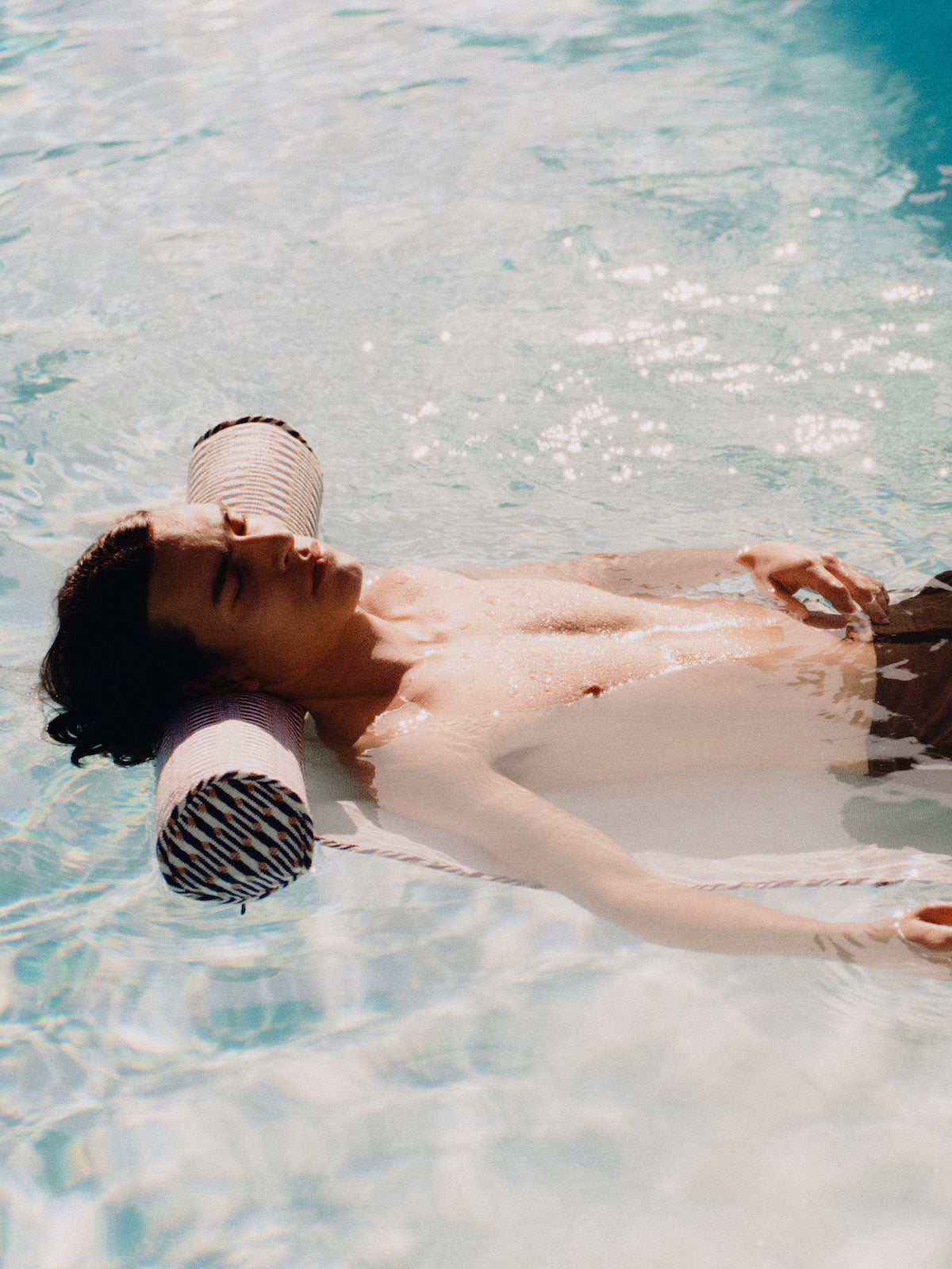 A man in a swimming pool relaxing on a luxury pool float