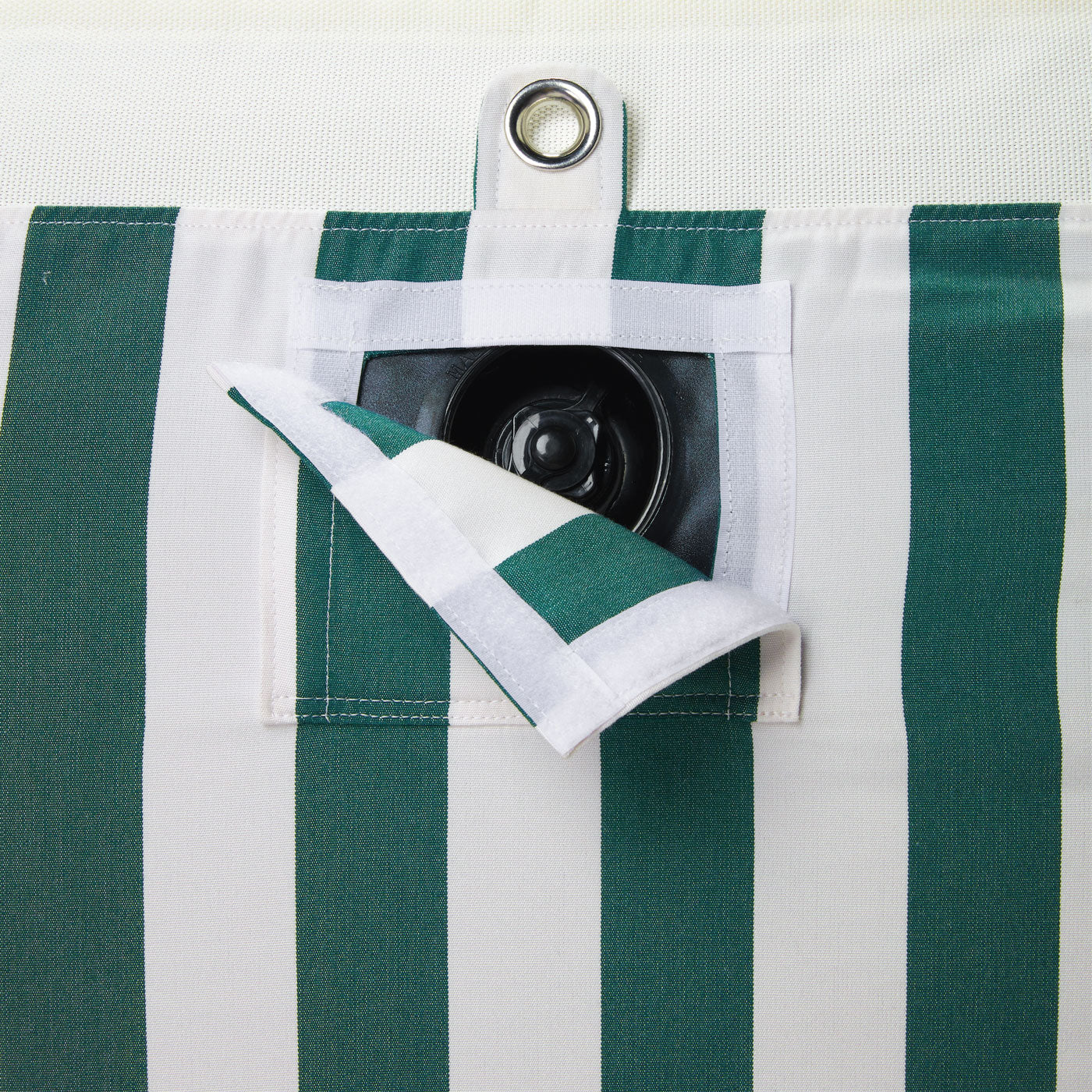 A pool float for an adult in a green and white stripe fabric upside down with a eyelet and velcro window showing a boston valve.  