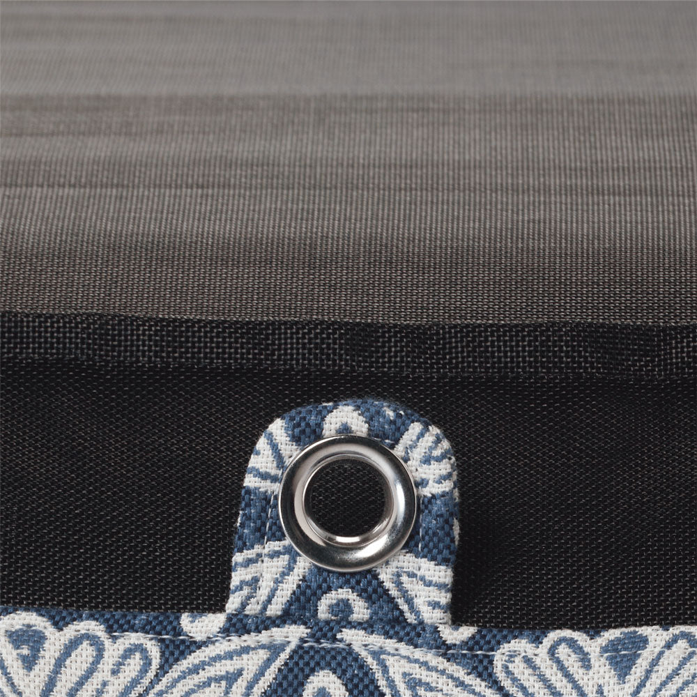 Une chaise longue de luxe à l'envers, à motifs bleus et blancs, dont la fermeture éclair, la base et les coutures sont visibles.