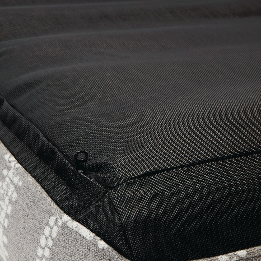 Une chaise longue de luxe à rayures grises et blanches, à l'envers, qui présente la fermeture éclair, la base et les coutures.